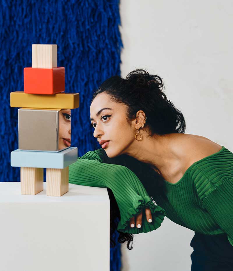 Close-up of desiger Akanksha Deo looking at one of her KONSTRUNDA art objects. Her face is reflected in the object.