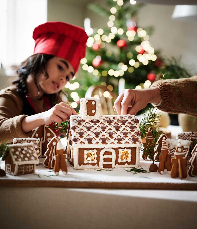 A child decorating a gingerbread house