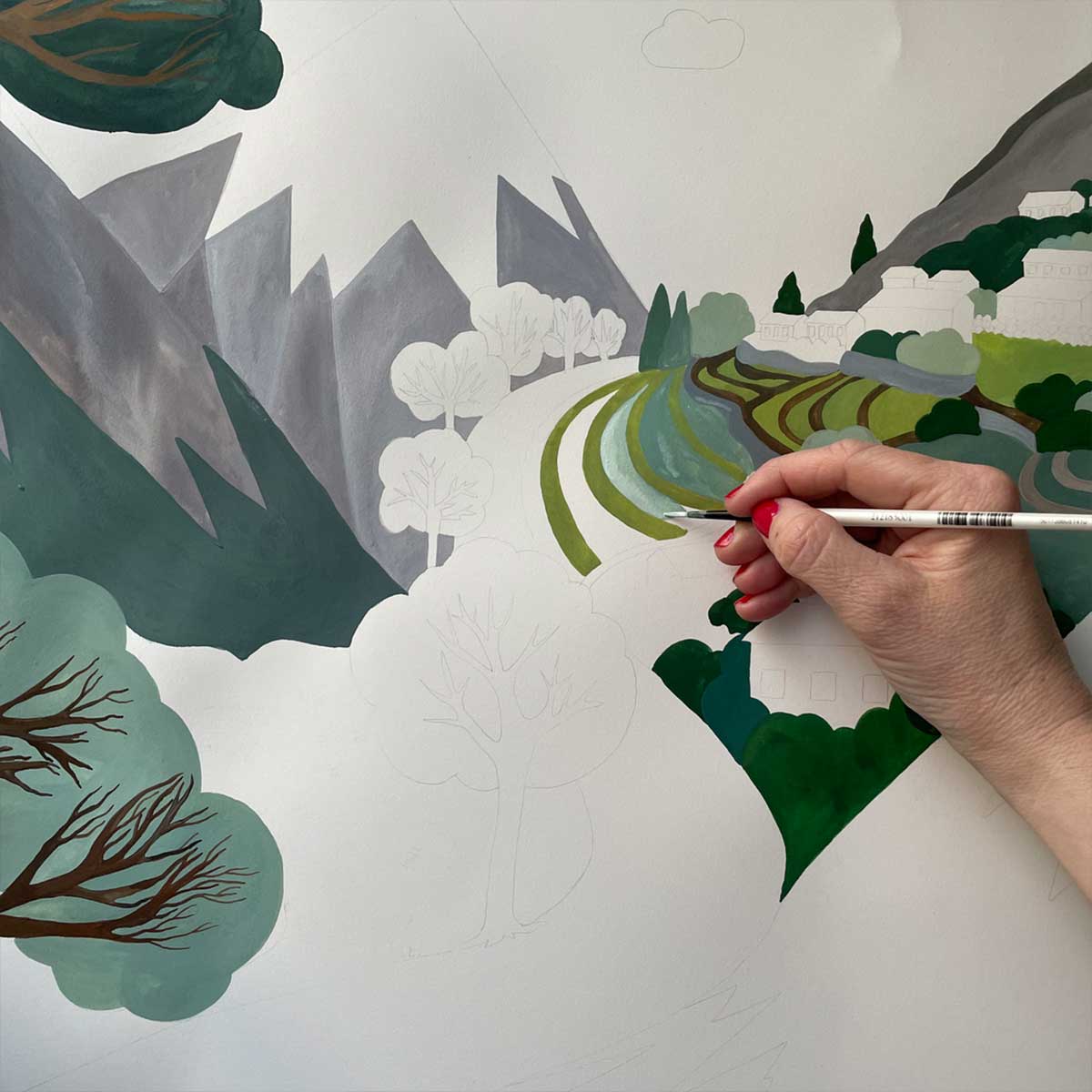 ALPTALL designer Malin Gyllensvaan hand-painting a Himalayan landscape for ALPTALL products in the children’s collection.